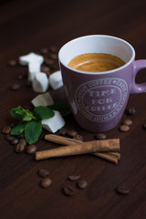composition of a cup of coffee with cinnamon, mint and coffee beans