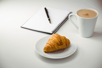 Notebook with pen and coffee by food