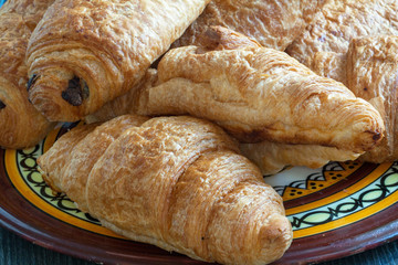 Croissants et pains au chocolat dans une assiette au décor breton