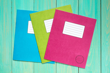 Exercise books on the blue wooden background