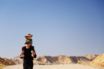 father with daughter hiking in the desert