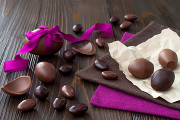 Chocolate Easter eggs over rustic wooden background. Copy space