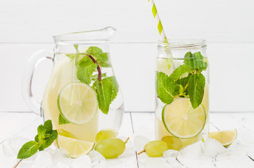 Refreshing homemade lime and mint cocktail over old vintage wooden table. Detox fruit infused flavored water. Clean eating. Copy space background