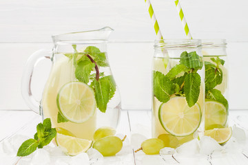 Refreshing homemade lime and mint cocktail over old vintage wooden table. Detox fruit infused flavored water. Clean eating.