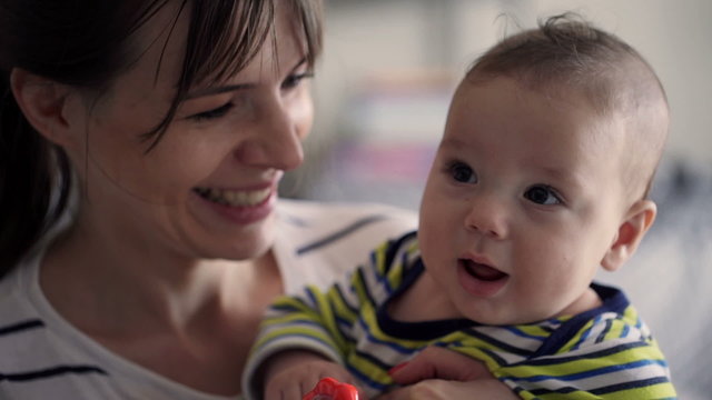 Portrait of young, happy mother with her cute small baby 
