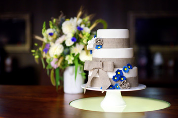 Three stories wedding cake decorated with blue flowers
