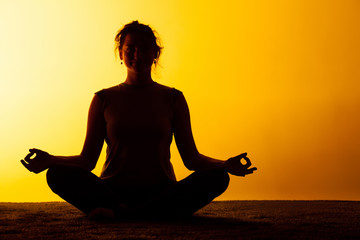 The woman practicing yoga in the sunset light