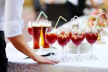 Waitress holding a dish of sangria glasses at some festive event