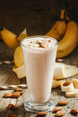 Banana smoothie with milk, ground almonds in a large cup on the