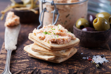Smoked salmon and soft cheese spread, mousse, pate in a jar with crackers and capers on a wooden...