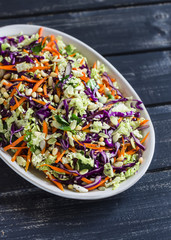 Cole slaw with seeds and pine nuts - delicious healthy vegetarian food. On a dark rustic wooden background