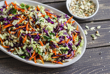Fresh Cole slaw with pumpkin, flax, sesame seeds and pine nuts - delicious healthy vegetarian food. On a dark rustic wooden background