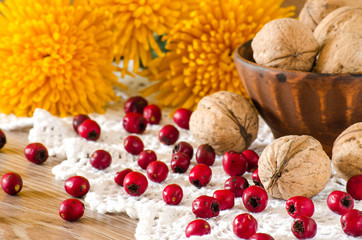 Walnuts in a bowl and hawthorn on the table