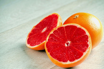 Halved red grapefruit on the table closeup