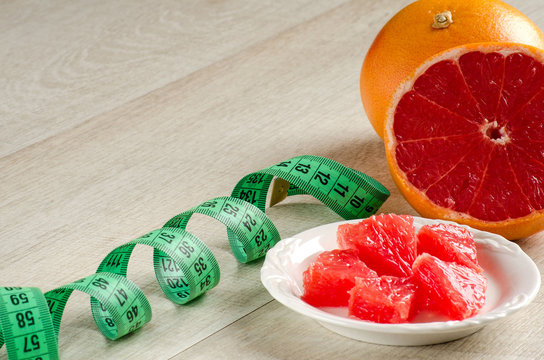 Slices of grapefruit and measuring tape on the table