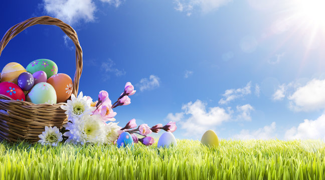 Basket of Easter Eggs With Flowers On Green Meadow
