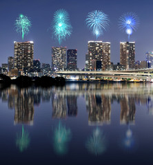 Fireworks celebrating over Tokyo cityscape with mirror reflectio