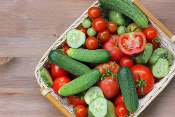 Fresh cucumbers and tomatoes in a basket