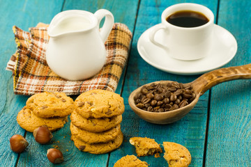 Chocolate chip cookies on an old vintage turquoise wooden background. Set table for breakfast. Hot Cup of coffee