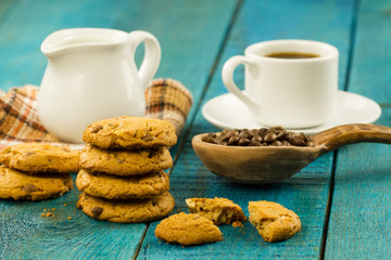 Chocolate chip cookies on an old vintage turquoise wooden background. Set table for breakfast. Hot Cup of coffee