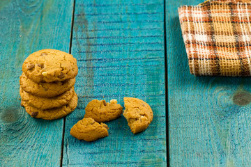 Chocolate chip cookies on an old vintage turquoise wooden background.