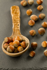 hazelnuts in spoon on black background, close up