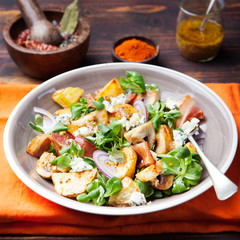 Potato salad with bacon, mushroom on orange napkin Wooden background