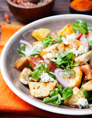 Potato salad with bacon, mushroom on orange napkin Wooden background