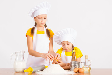 two little chef's in the kitchen playing cook out flour