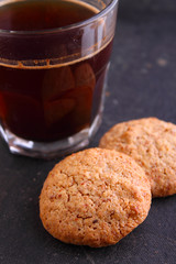 almond cookies on a black background with a cup of coffee