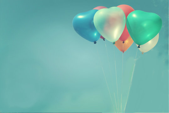The colorful heart-shaped balloons with blue sky background in vintage style, concept of love in summer and valentine, wedding