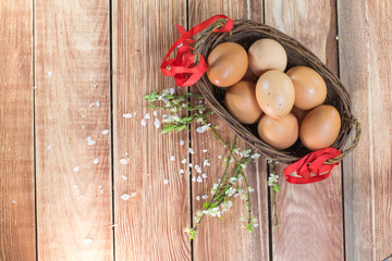 Easter - Hen Eggs in a Wicker Basket with a Ribbon and Spring Fl