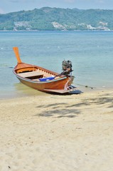 Fototapeta premium Thai boat on the beach against the backdrop of sea and mountains
