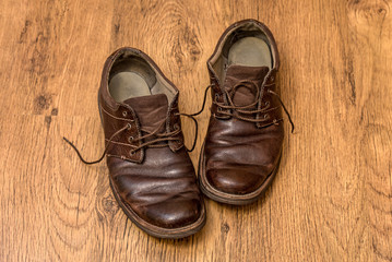 Fototapeta na wymiar Men's old boots on wood background