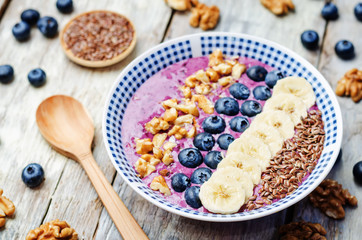 Blueberries healthy smoothies breakfast bowls with nuts, seeds and fruits. toning. selective focus