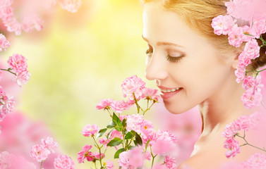 Fototapeta premium Beauty face of young beautiful woman with pink flowers in her ha