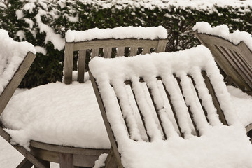 Winter - Tisch und Stühle aus Holz im Garten - tief verschneit