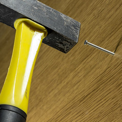 Hammering nail into a wooden surface