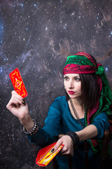 Young beautiful fortune teller wondering on the Tarot cards. Predicting the future, access to the...