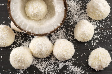 Fresh coconut and coconut cookies on dark background