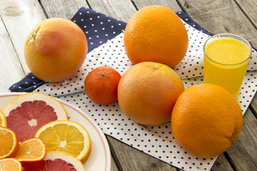 Orange juice and citrus slices on wooden table