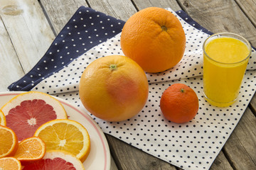 Orange juice and citrus slices on wooden table