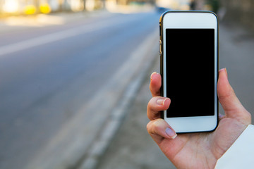 a girl gets on the a telephone hip, takes pictures a street