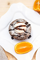 Warm dessert chocolate cake Fondant served on plate with ice-cream ball, almond chips, mint, icing, citron, cacao