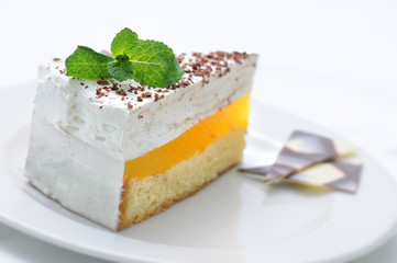 cream cake with mint leaf and chocolate decoration on white plate, sweet dessert , patisserie, on-line shop photography, gelatinous tart
