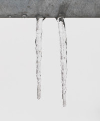 Large icicles hanging on the roof of the house in springtime