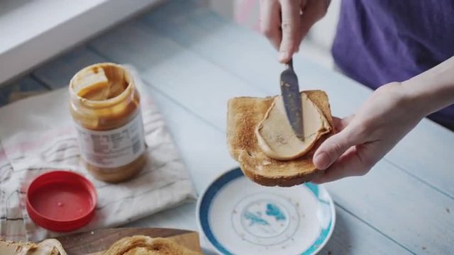 Woman makes a peanut butter sandwich