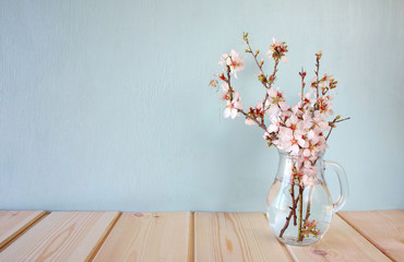 spring bouquet of flowers on the wooden table with mint background. vintage filtered image
