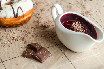 Donut with jam watered white chocolate. Dark chocolate, milk cho