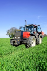 Landwirt mit Schlepper und Düngerstreuer